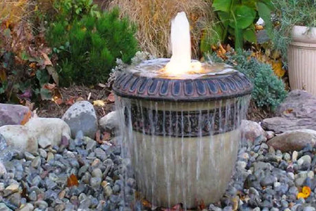 Vase pondless water feature in a garden, overflowing into rocks